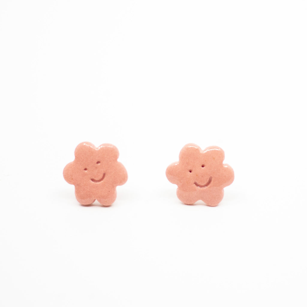 Pair of pink flower-shaped earrings on a white background