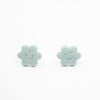 Pair of light blue flower-shaped earrings on a white background