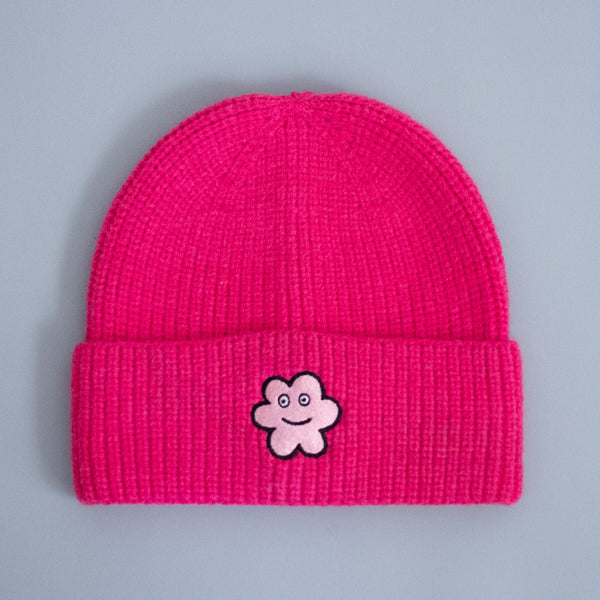 Pink beanie with a happy luci embroidered patch. 