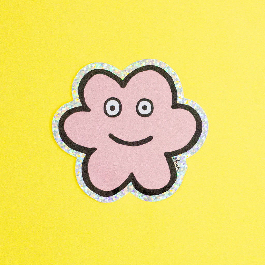 A die-cut sticker featuring a cute flower shaped character with a holographic border, set against a plain yellow background.