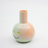 Ceramic vase with a smiley face design on a white background