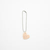 Heart-shaped charm on a chain against a white background