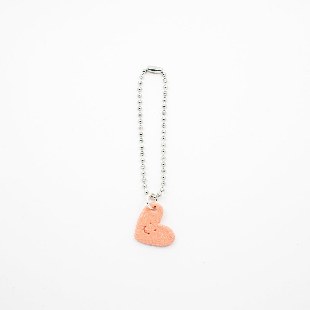 Keychain with a pink heart-shaped charm on a white background