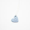 Blue heart-shaped necklace with a smiley face on a white background