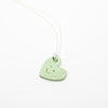 Green heart-shaped pendant on a white background