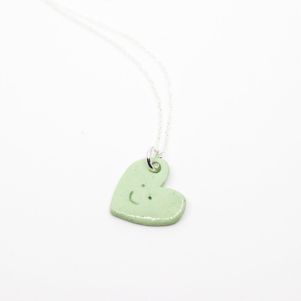 Green heart-shaped pendant on a white background