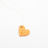 Heart-shaped pendant with a smiley face on a white background