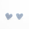 Heart-shaped earrings with smiley faces on a white background