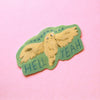 A die-cut sticker featuring a cartoon owl with outstretched wings on a light green background, with the text 'HELL YEAH' in blue and 'OH-H-H-H-H-H' in white. The sticker is photographed on a solid pink background.