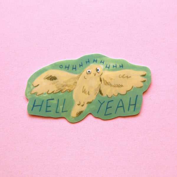 A die-cut sticker featuring a cartoon owl with wings spread, on a green background with the text 'HELL YEAH' and 'OHHHHHHHH'. The sticker is displayed on a solid pink background.