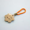 Keychain with a ceramic charm and orange carabiner on a light gray background