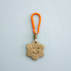 Keychain with star-shaped ceramic charm and orange carabiner on a light blue background