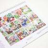 A spiral-bound printed page featuring a collage of colourful illustrated scenes with cats, plants, and home decor, photographed on a white background.