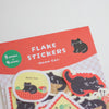 A package of 'Home Cat' flake stickers featuring black and white cat illustrations on a red header card, with several sample stickers displayed below.
