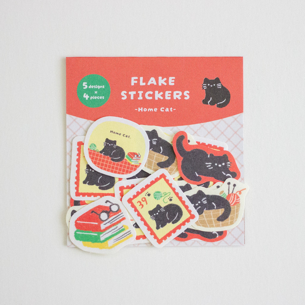 A package of home cat themed flake stickers, featuring a red header card with white text and several colourful die-cut stickers showing black cats in various scenarios, displayed on a light grey background.