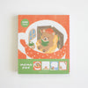 A square memo pad with a warm orange cover featuring an illustration of a teddy bear reading a book, with a green band at the bottom labeled 'memo pad' and small sample note areas.