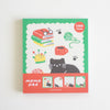 A square memo pad with a colourful illustrated cover featuring a black cat, books, glasses, yarn ball, mug, paw prints, and small preview panels along the bottom. The top right says '100 sheets' and the bottom reads 'memo pad'.