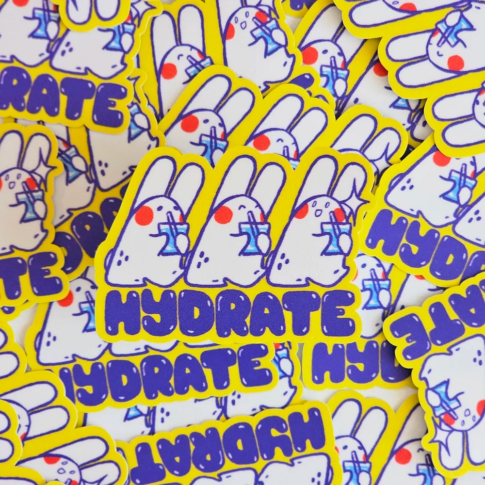 A pile of die-cut stickers featuring a white cartoon rabbit with blue glasses and the word 'HYDRATE' in purple, surrounded by a bright yellow border.