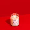 Candle in a glass jar on a red background