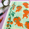 Print with cute tomato character illustrations on a purple surface with stationery items.