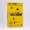 A yellow puzzle book titled 'A Chorus of Questions Angela Kirkwoof' shown standing upright against a light grey background. The cover features multiple cartoon dog illustrations and black text, with the LE PUZZ brand name prominently displayed at the top and bottom.