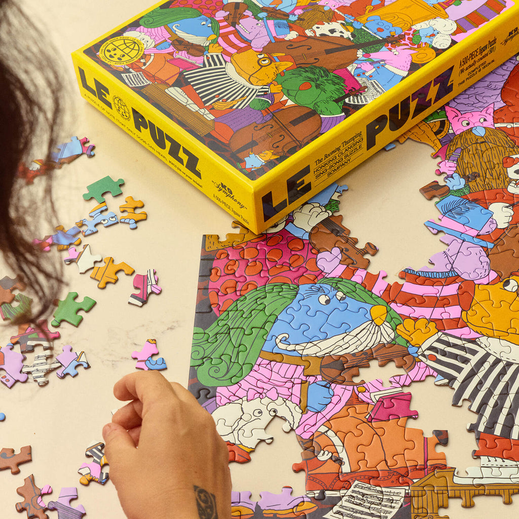 Person assembling a puzzle of a colour illustrations.