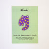 Purple cat-shaped iron-on embroidery patch with yellow dots on a green grid card.