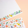 A letterset consisting writing paper sheets and envelopes with colourful illustrated borders featuring birds, and flowers.