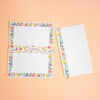 A letterset consisting writing paper sheets and envelopes with colourful illustrated borders featuring birds, flowers, and the text 'kusamura Letter Writing Set' on a peach background.