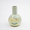Ceramic vase with a smiley face design on a white background