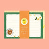 A cute stationery letter set from 'valo's kitchen' featuring a green and orange design with lined writing areas, a cartoon bear illustration, and small white flowers, presented on a solid peach background.