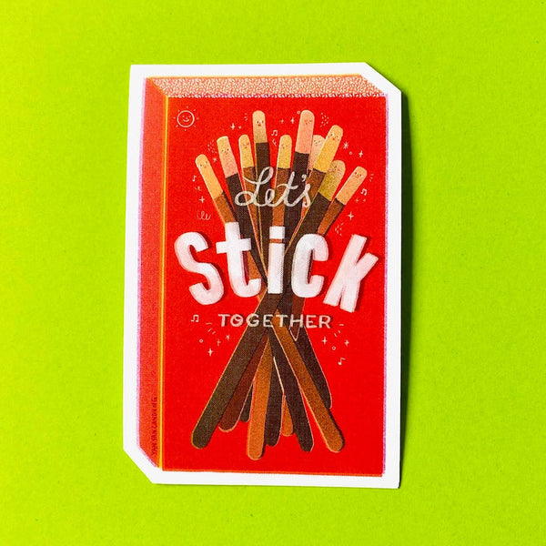 A rectangular sticker featuring a red matchbox-style design with the words 'Let's Stick Together' and an illustration of assorted stick-like treats, shown on a bright lime green background.
