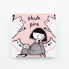 Enamel pin featuring a hand-drawn girl and cat with matching expressions and outfits, displayed on a pink backing card with cat illustrations and “shuh. pins” branding.