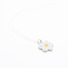 Sterling silver necklace featuring a light white ceramic flower-shaped pendant with a yellow dot in the centre, displayed on a white background.