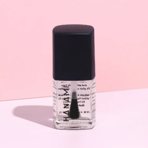 Nail polish bottle with black cap on a pink background