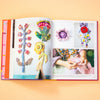 Open book displaying colorful crochet patterns on a peach background