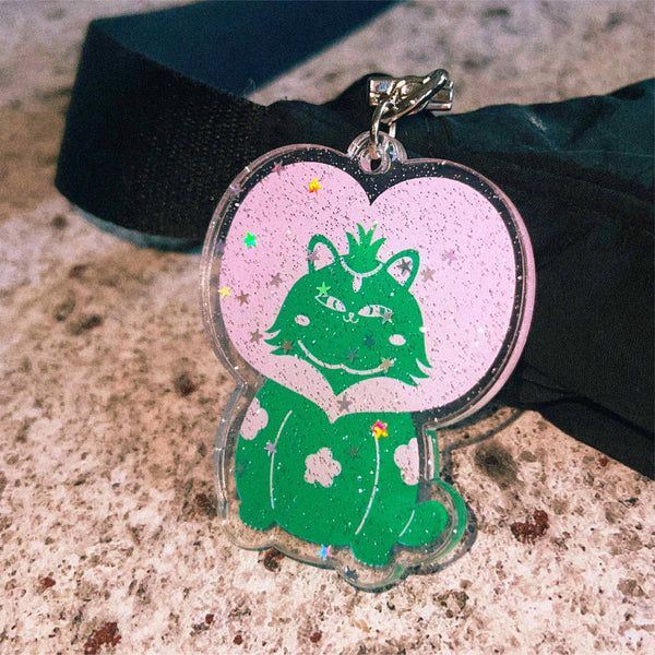 A glittery dot and star keychain with a heart shape and cat.