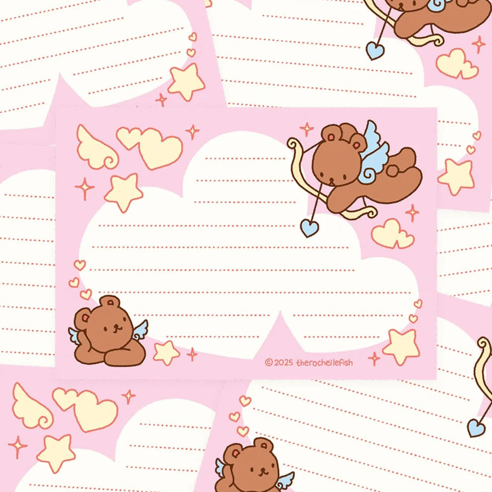 Pink and white stationery cards featuring cute cartoon cupid illustrations, pastel hearts, stars, and lined writing areas.