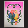 A colourful art print featuring two kissing birds framed by a heart-shaped floral border, displayed on a white sheet against a dark background.