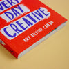 A book titled 'Make Every day Creative' on a yellow background