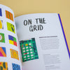 Book with writing and pictures of patterns on a yellow background