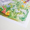 A close-up of a watercolour art print showing a small yellow duckling walking through a green meadow with white and blue flowers.