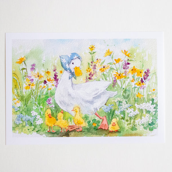 A watercolour art print depicting a mother duck wearing a blue bonnet with her four yellow ducklings in a vibrant field of yellow, purple, and white wildflowers, shown on a white paper sheet against a light background.