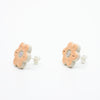 A photo of the marigold stud earrings. Ceramic stud earrings with a flower shape and peach colour leaves with a lilac centre. Side view shows sterling silver stud backing. 
