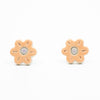 A photo of the marigold stud earrings. Ceramic stud earrings with a flower shape and peach colour leaves with a lilac centre.