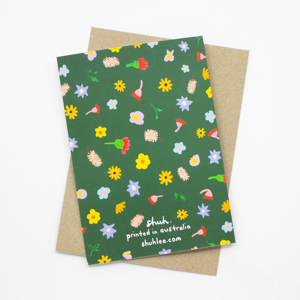 Back view of the Meadow print card. Bright wildflowers over a green background. 