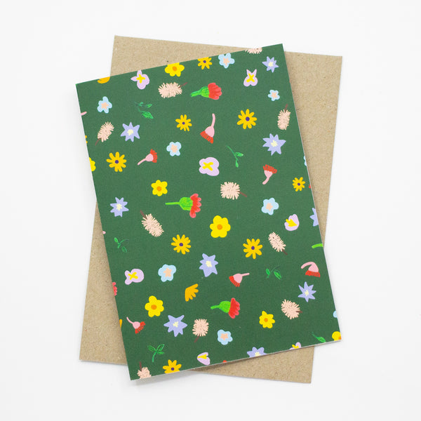 Front view of the Meadow print card. Bright wildflowers over a green background. 