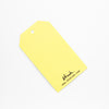 Yellow tag with 'shuh.' branding on a white background