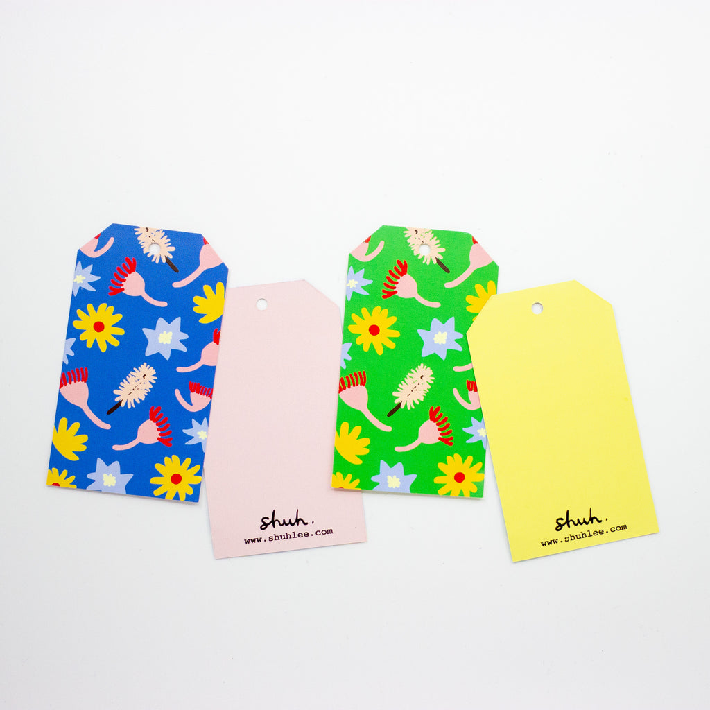 Four colourful product tags with floral and abstract designs on a white background.