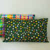 A view of the Meadow pillow case, with pillow inside. Illustrated wildflowers on a meadow green background.